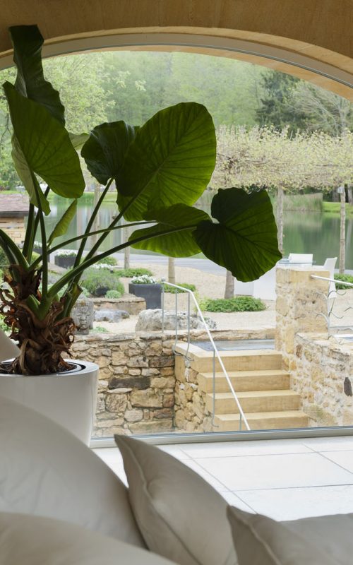 Large arched window with outlook to garden and lake. The white chair is from B&B Italia