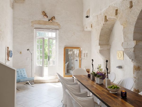 Dining room in converted french chapel. The floor is limestone and the table designed by Joris von Grinsven